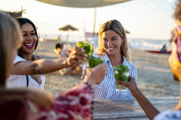 Amici che brindano con drink in spiaggia.